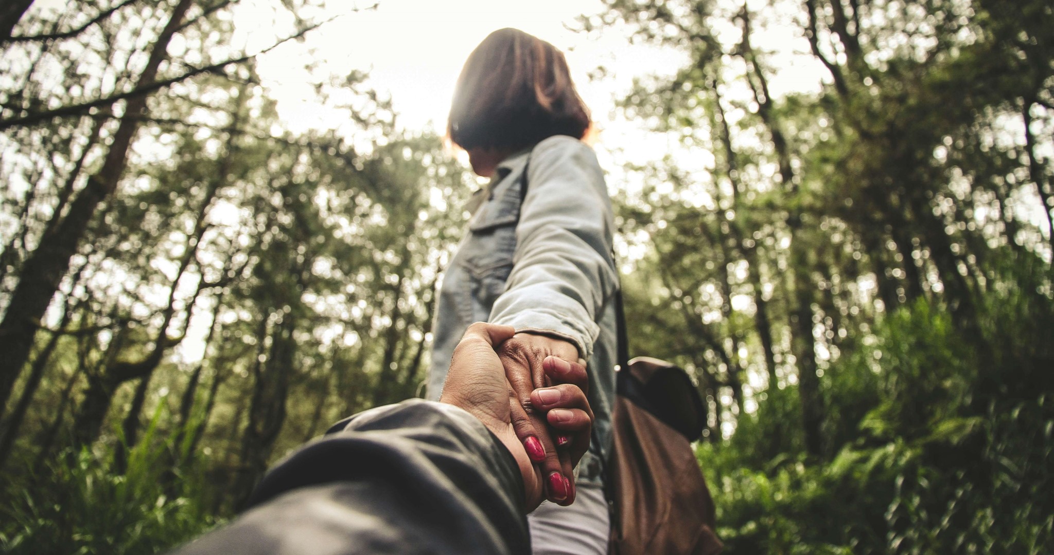 Woman guiding companion through the woods.